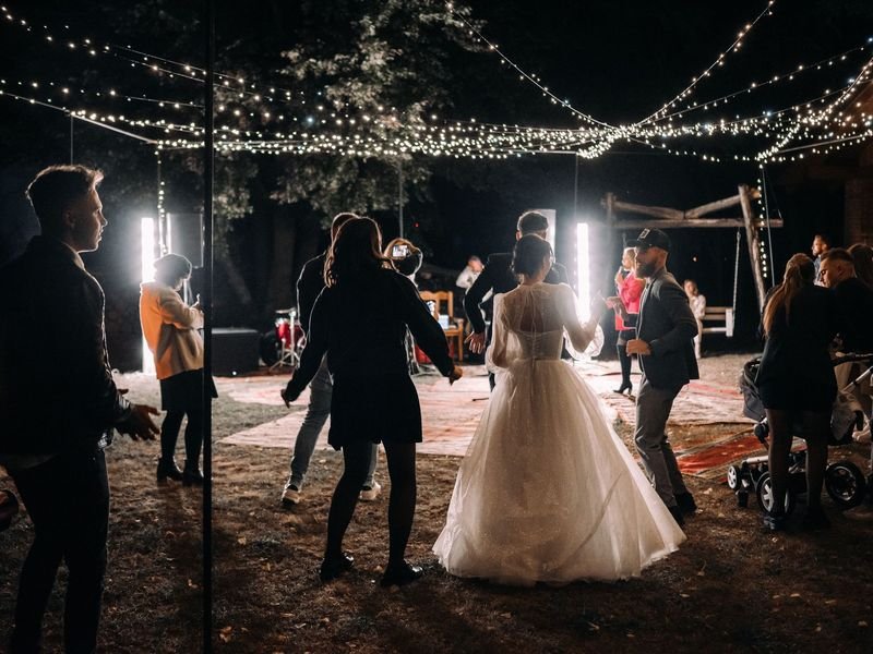 Invitados bailando bajo luces en una boda
