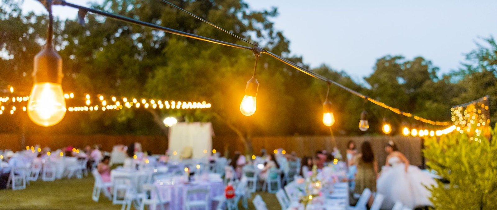 Recepción de boda al aire libre con luces al atardecer